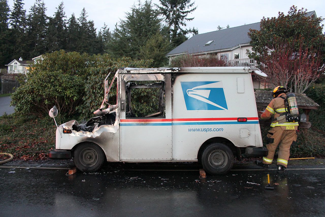 Kyle Jensen / The Record                                A firefighter pulls charred mail from the rear of the mail truck.