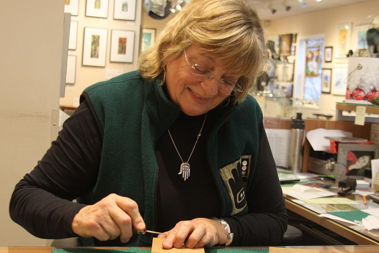 Diane Tompkinson, a Coupeville artist, demonstrates a linocut at Penn Cove Gallery in Coupeville Thursday, Dec. 1. The holidays are a busy time for the printmaker. Photo by Ron Newberry/Whidbey News-Times