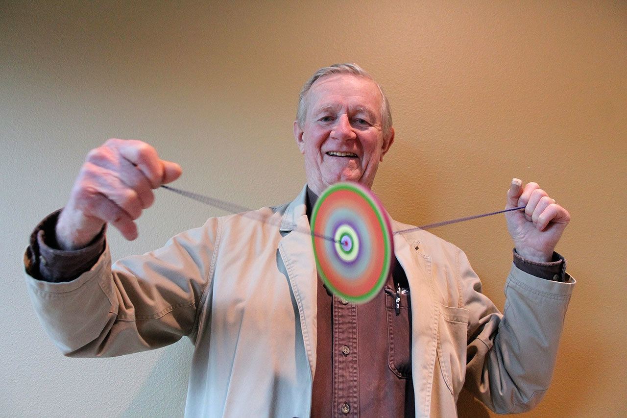 Kyle Jensen / The Record                                Rufus Rose spins one of his colored branch spinners by pulling the strings apart, adding tension.