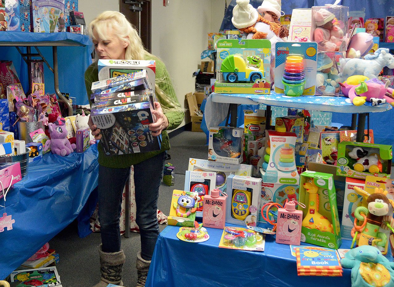 Volunteer Christian Wertz organizes toy displays Thursday in preparation for the opening of Holiday House, a program that provides Christmas gifts to families in need in Oak Harbor and Coupeville. Photo by Megan Hansen/Whidbey News-Times