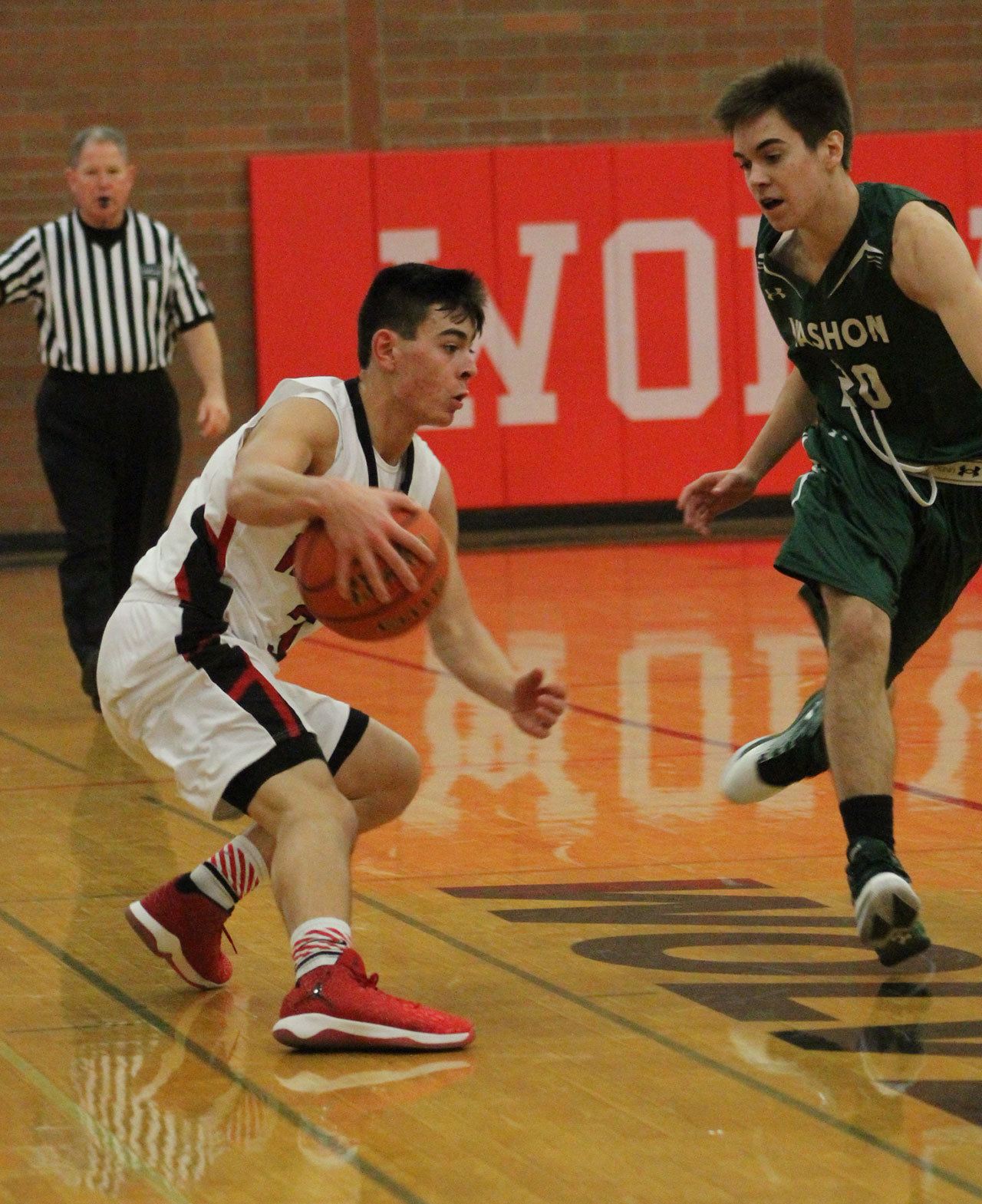 Hunter Smith uses a crossover dribble to try to get by Vashon Island’s Jacob Chavez. (Photo by Jim Waller)