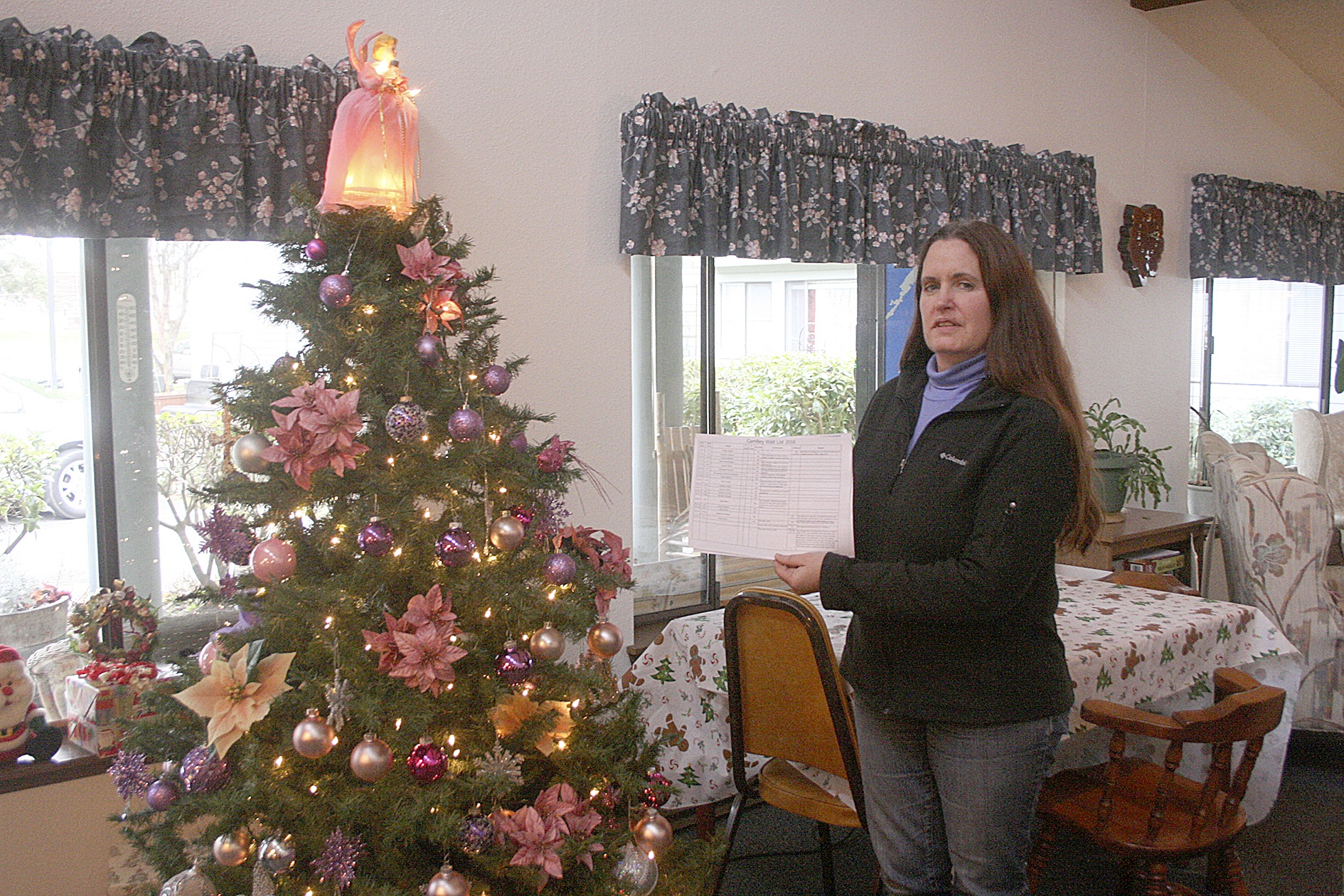 Photo by Dan Warn / Whidbey News-Times                                Near the Christmas tree in a community room at Senior Service’s CamBey apartments, Kaci Cheyne, manager of the complex, refers to the establishment’s waiting list, a document with 21 names, a physical representation of their inability to find affordable senior housing in Coupeville.