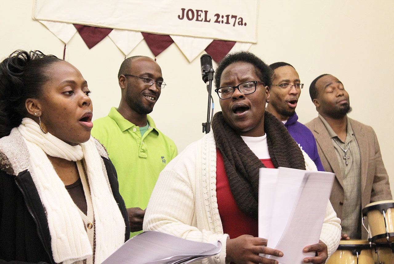 Photo by Patricia Guthrie/Whidbey News-Times                                The United Fellowship Community Choir warms up for Martin Luther King, Jr. celebrations at House of Prayer in Oak Harbor. The group performed Friday at Naval Air Station Whidbey Island and will be part of a Sunday service. Singing in the front row are Genia Boyles, left, and Loretta Byrd. Kahnvis Gordon (left) Tyrone Vester (middle) and Charles Boyles III are in the back row.