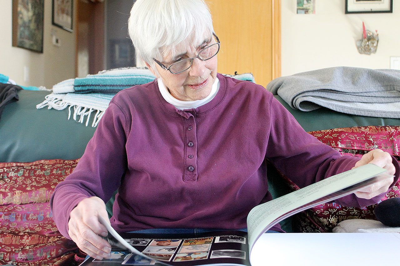 Jean Shaw, a Langley resident and retired teacher, looks through her lifelong scrapbook, “Bits & Pieces: 75 Years of Random Memories.” Shaw is considered an instrumental piece to the development of drama amongst youth on South Whidbey. Photo by Evan Thompson/Whidbey News Group
