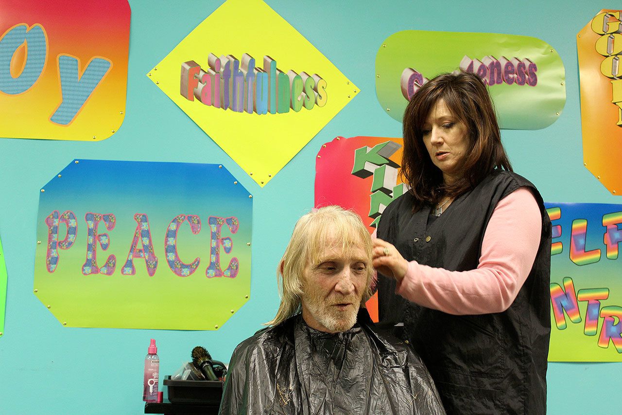 Stylist Spring Roehm trims the hair of Charles Jackson Thursday at Langley’s Island Church. Free haircuts, a hot meal and other services were offered during the annual Homeless Point in Time count to encourage people in need of shelter to seek help. Volunteers also scoured Whidbey Island in search of the homeless.                                Photo by Patricia Guthrie/Whidbey News-Times