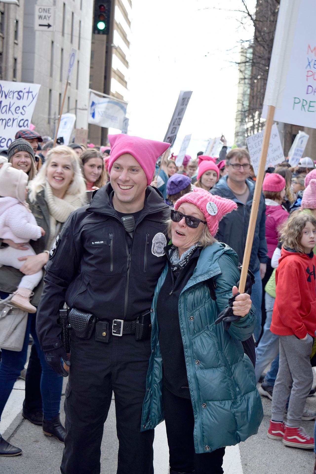 Photo by Patricia Guthrie/Whidbey News-Times                                Seattle Police Officer Benjamin Frieler dons a pink hat and poses with Catherine Lichterman of Langley Saturday at the Womxn’s March on Seattle. Hundreds of Whidbey Island residents were among the record-breaking crowd, estimated at 120,000 to 175,000.