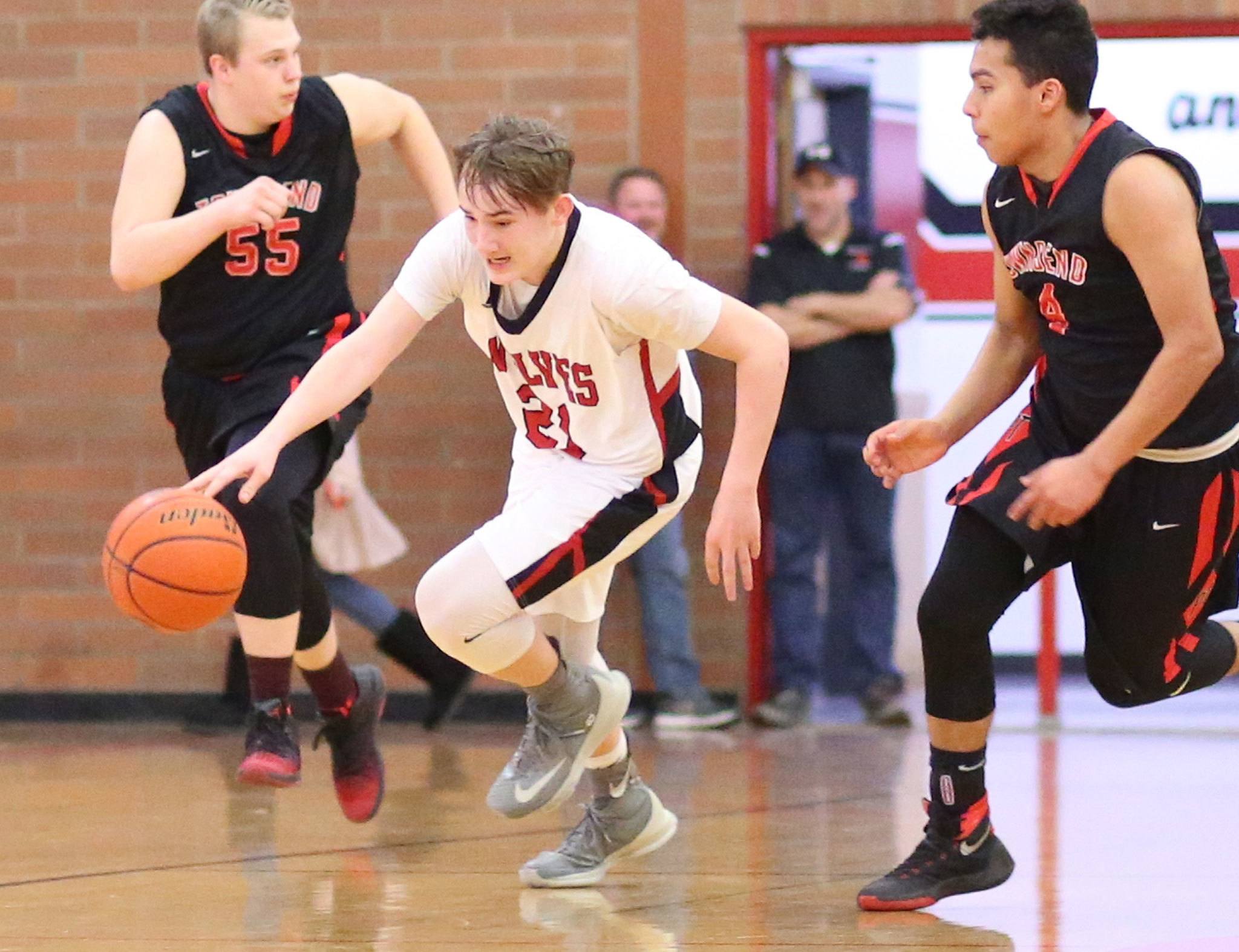 Ethan Spark races up the court by Port Townsend’s Kaiden Parcher (55) and Jacob Boucher. (Photo by John Fisken)