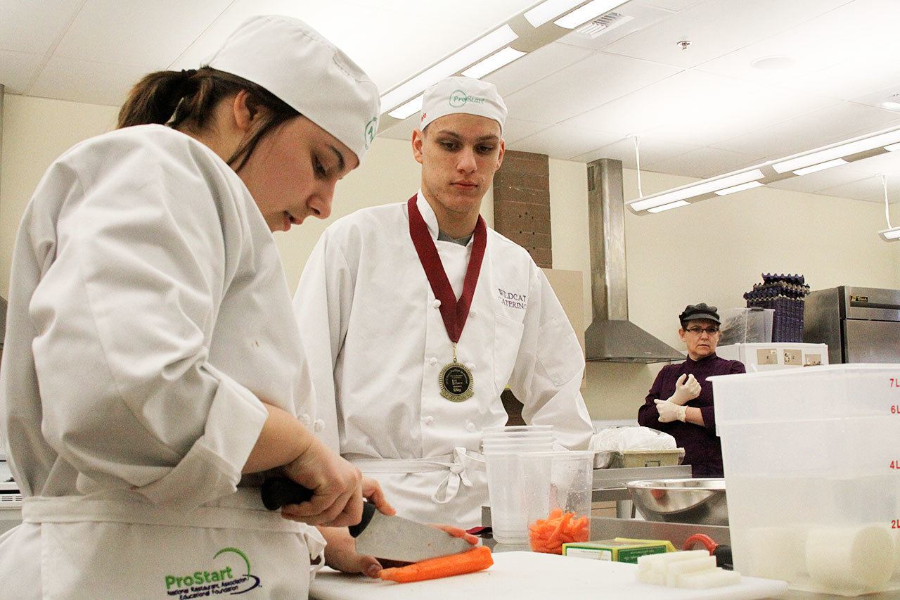 Sydney Dickinson, left, Garrett Karney and other Oak Harbor High School students work on knife skills while preparing dishes during Chef Mary Arthur’s culinary arts class Thursday, Feb. 23, 2017. The school’s culinary arts team won a state championship for the eighth time in 12 years on Saturday and will now advance to the National ProStart Invitational in Charleston, S.C. Photo by Ron Newberry/Whidbey News-Times