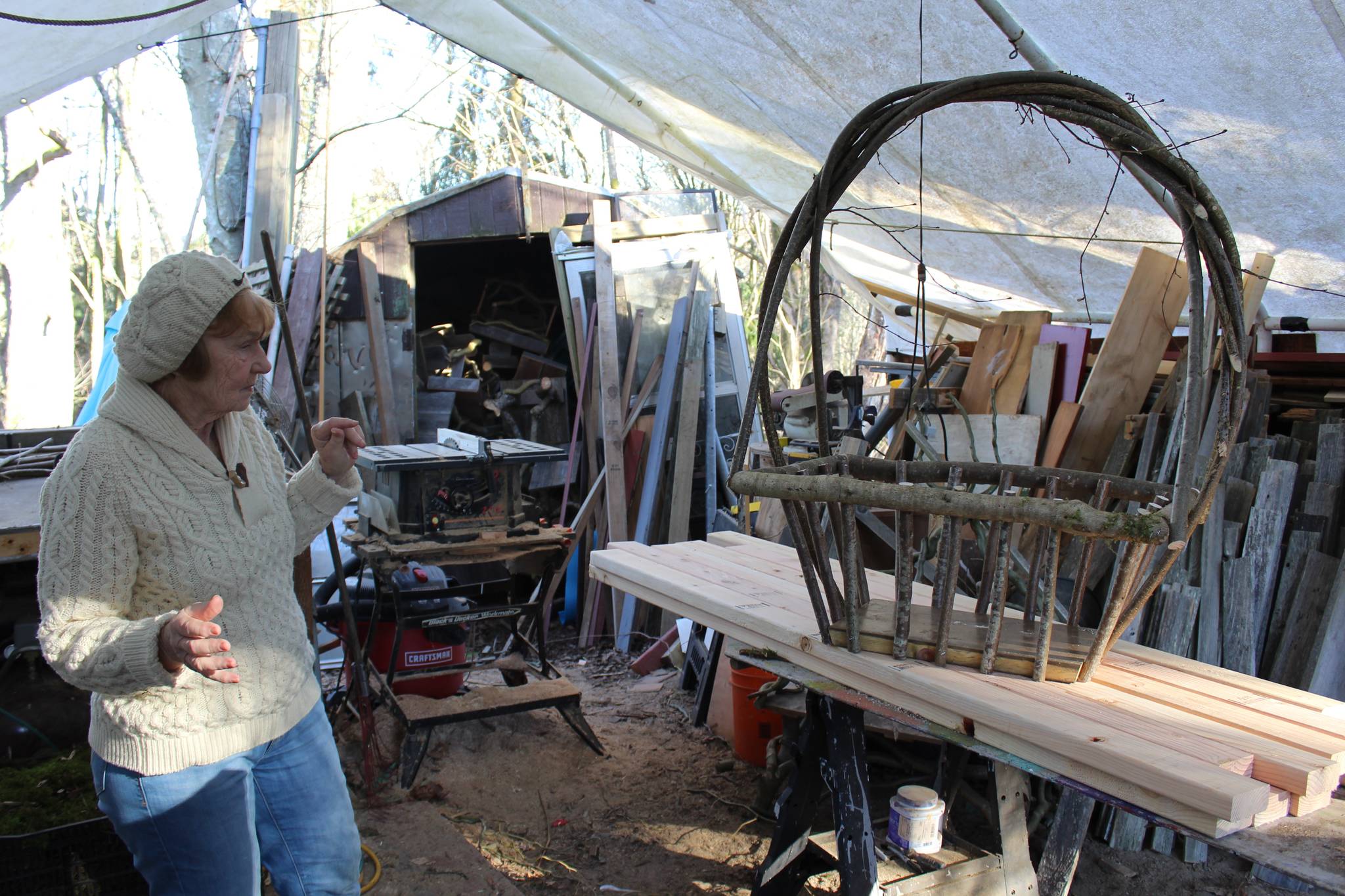 Vanca Lumsden sizes up a willow basket she and her husband made in their Freeland work studio. Photo by Patricia Guthrie/Whidbey News-Times