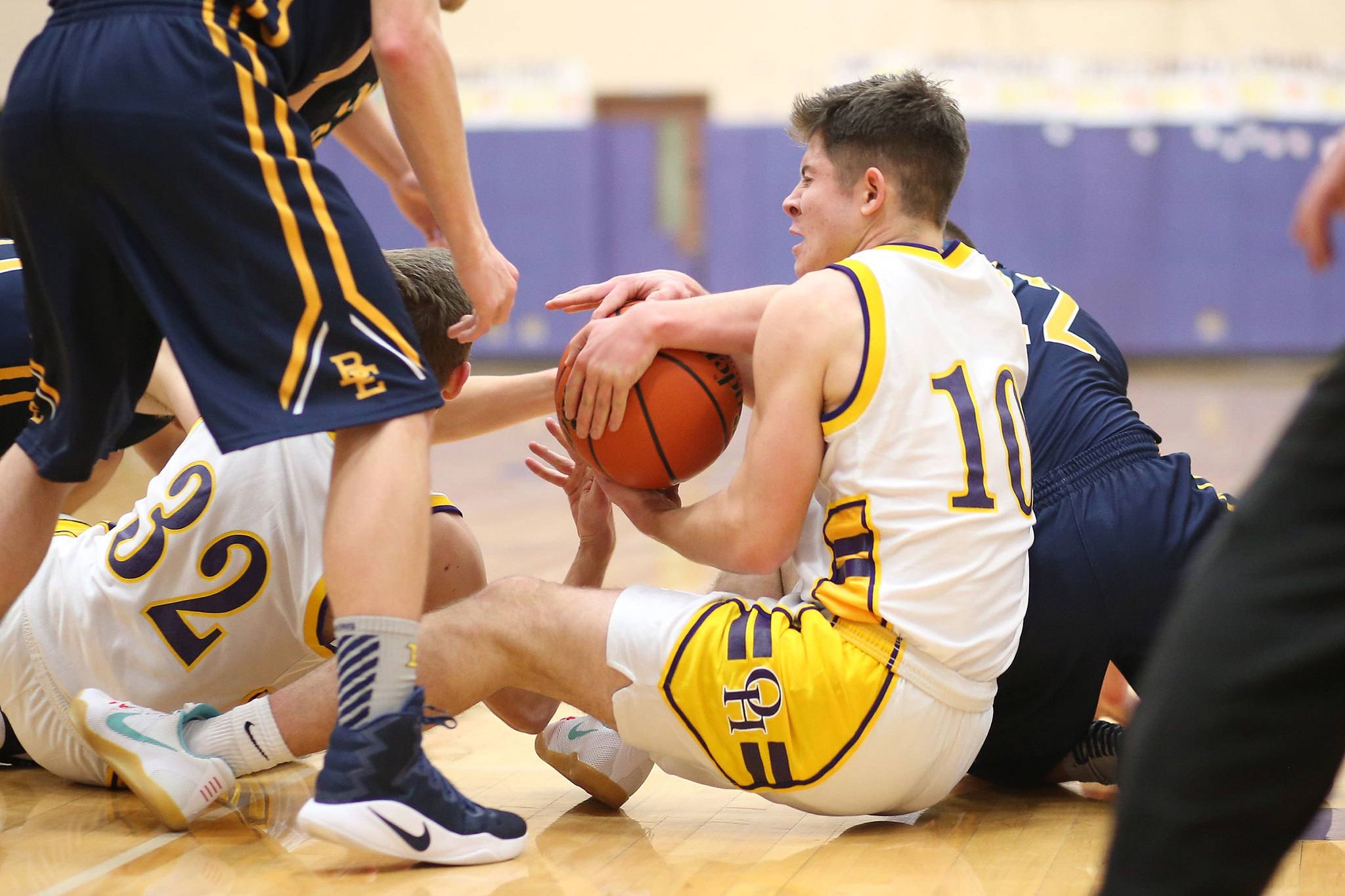 JJ Mitchell (10) and Adam Nelson (32) scrap for a loose ball. (Photo by John Fisken)