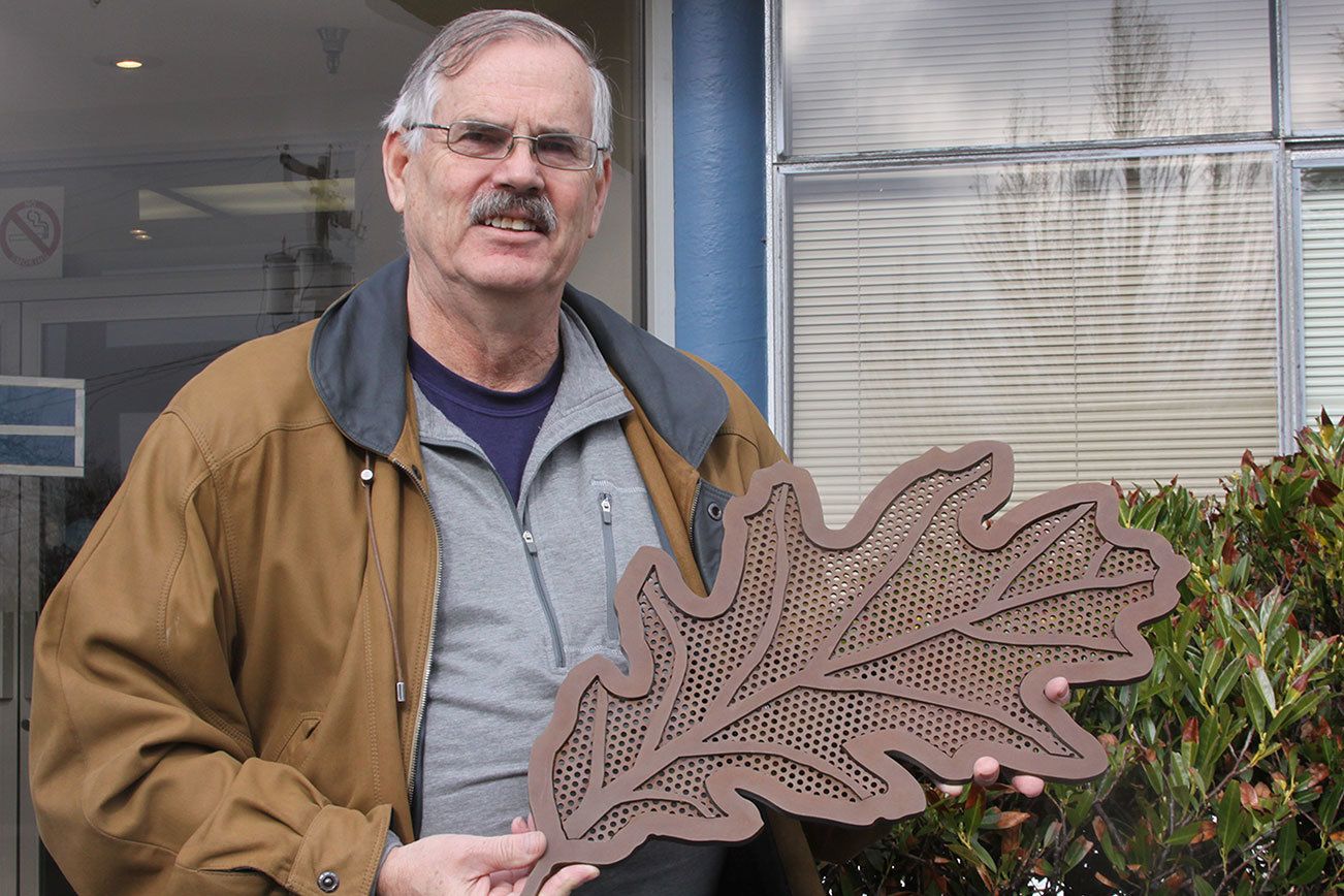 Skip Pohtilla, chairman of the Oak Harbor Arts Commission, shows a much smaller version of the sort of oak leaves that will be part of Oak Harbor’s new public art piece Thursday, Feb. 23, 2017 in front of City Hall. The “Autumn Leaves” metal sculpture will show 10 leaves blowing in the wind. The sculpture will rest on the side of State Highway 20 near NE 4th Avenue. Photo by Ron Newberry/Whidbey News-Times