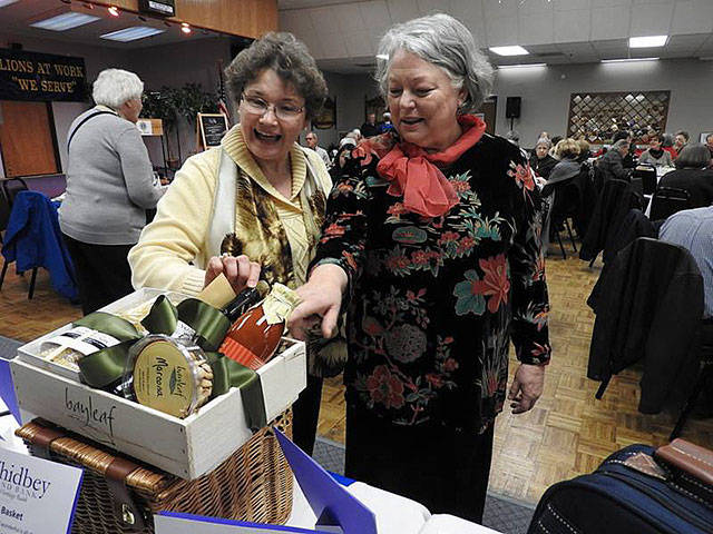 Lions Jan Graham, left, and Jackier Fuesier, right, check out items during the silent auction. Photo by Lion Marsha Phay