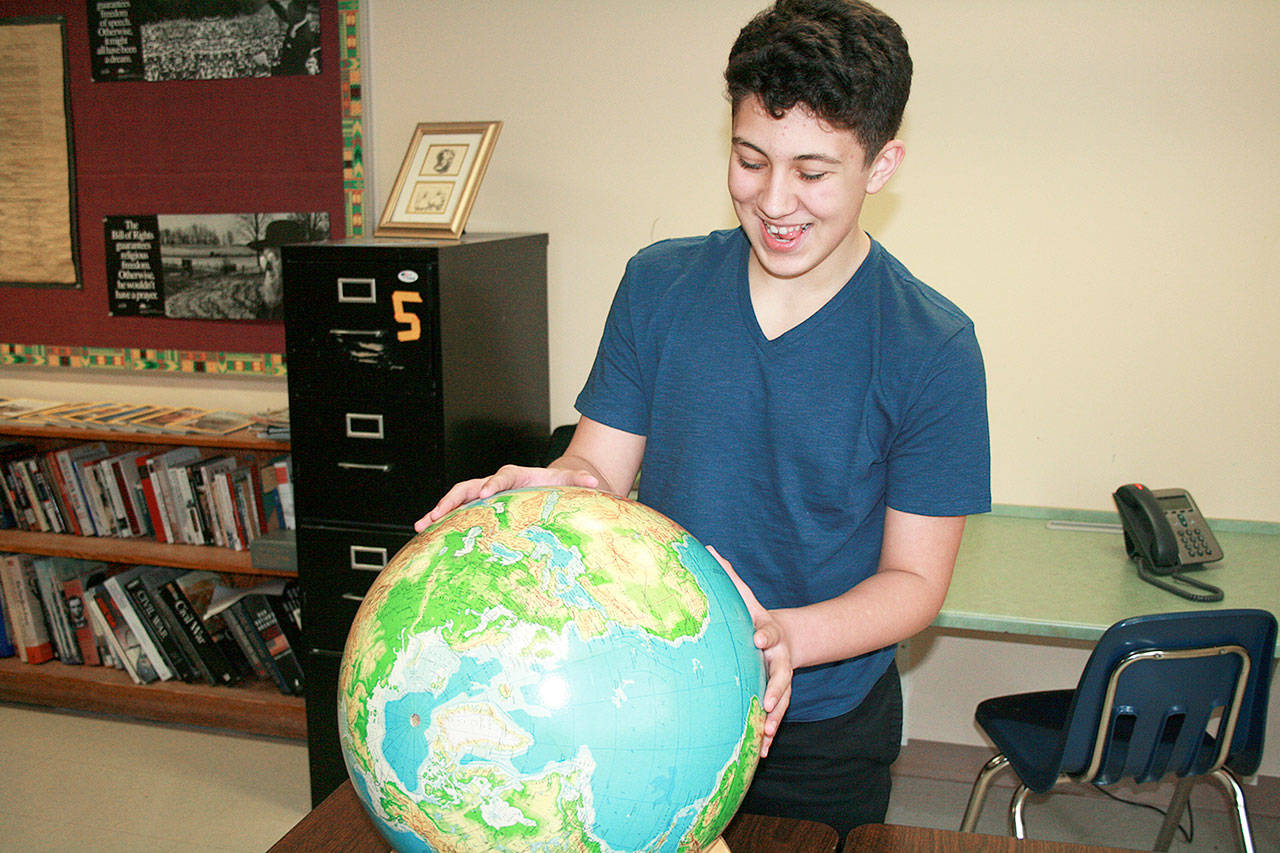 Zachary Badaouie examines a globe during his history class at Oak Harbor Middle School. He is currently in preparation for the state geography bee. Photo by Daniel Warn/Whidbey News-Times