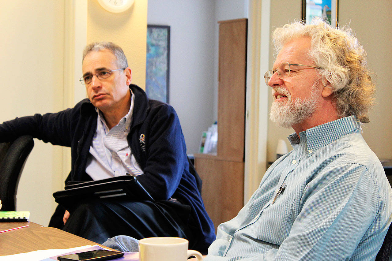 Michael Shuman, left, author of a report on the “hidden costs” of Naval Air Station Whidbey Island, visits Island County Economic Development Office in Coupeville on Tuesday. Larry Morrell, right, is with the citizen group, Sustainable Economy Collaborative, that hired Shuman for the economic impact investigation. Photo by Patricia Guthrie/Whidbey News-Times