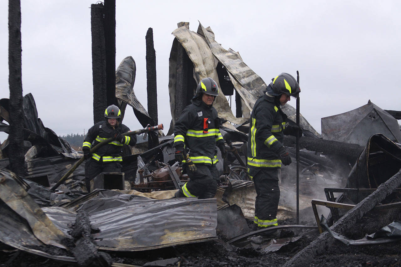 Firefighters with Central Whidbey Fire & Rescue look for hot spots Tuesday morning at Willowood Farm on Central Whidbey. A fire Monday night destroyed the historic Smith Barn. As of Tuesday morning, a cause had not been determined. Photo by Ron Newberry/Whidbey News-Times