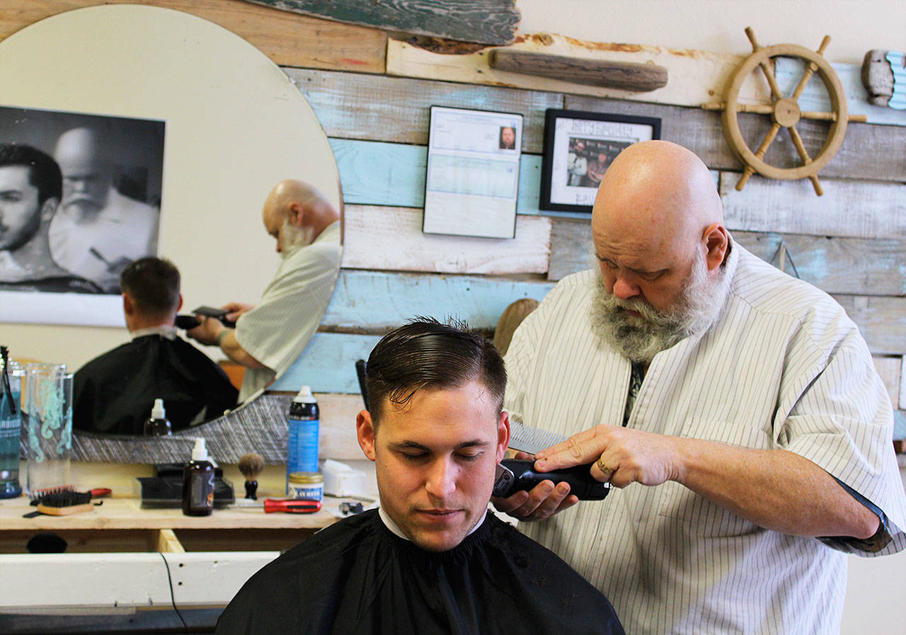 Yondersea owner Kevin Bell gives Petty Officer, 2nd class, Joshua Grant a close cut at his new downtown Oak Harbor barber shop. Photo by Patricia Guthrie/Whidbey News-Times