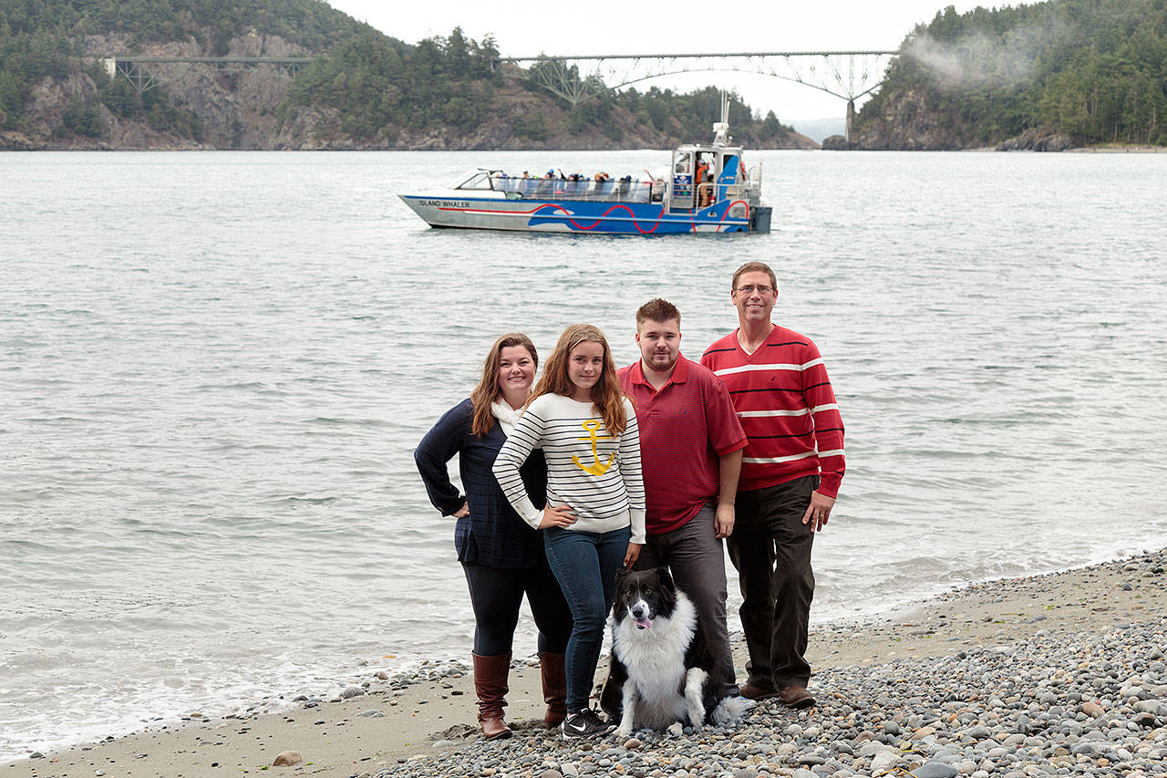 Terica and Brett Ginther with children Brooklyn Taylor and Austin Taylor all are part of the Deception Pass Tours team. They stand on the beach at Deception Pass State Park in front of their boat in 2015. Photo courtesy Terica Ginther.