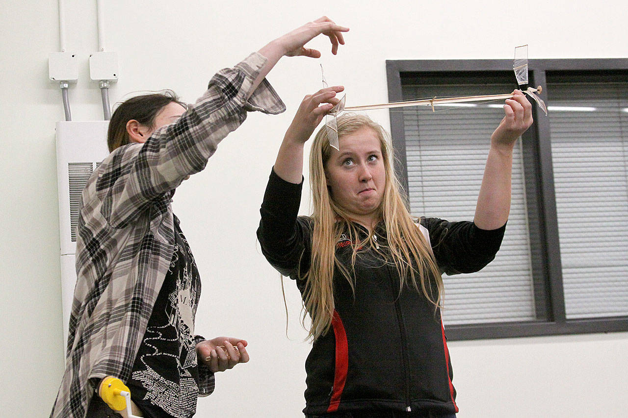 Madison Rixe, left, and McKenzie Meyer give a demonstration of the helicopter event at the Coupeville school board meeting last month. Rixe and Meyer are among 13 Coupeville High School students who will participate in the Science Olympiad state competition at Highline College April 15. Photo by Ron Newberry/Whidbey News-Times