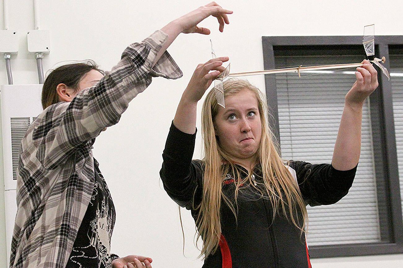Madison Rixe, left, and McKenzie Meyer give a demonstration of the helicopter event at the Coupeville school board meeting last month. Rixe and Meyer are among 13 Coupeville High School students who will participate in the Science Olympiad state competition at Highline College April 15. Photo by Ron Newberry/Whidbey News-Times