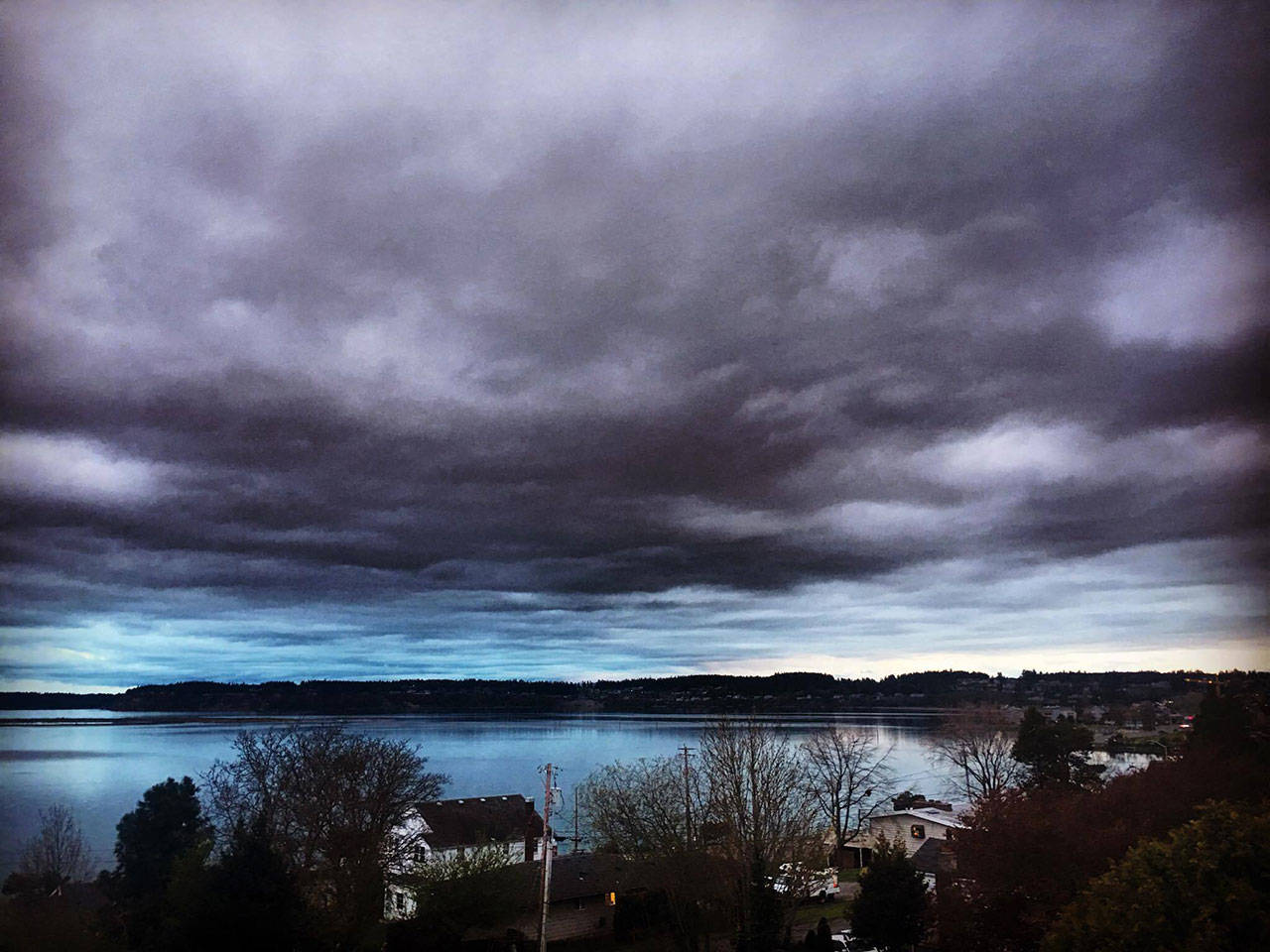 As a hint of blue begins to show over the horizon earlier this month, its reflection over the Oak Harbor Marina casts a purple hue on the day’s cloud cover. Photo by Rachel Ann Warner