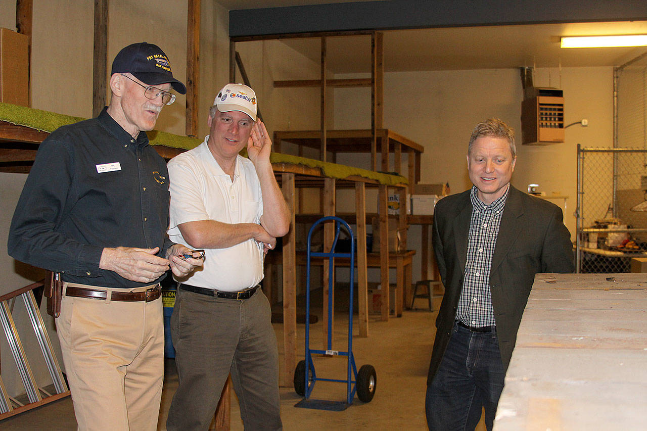 Wil Shellenberger, left, president of the PBY Memorial Foundation, Mark Christopher and Jim Dever examine a crate packed with beaching gear for a PBY stored in a warehouse behind the PBY-Naval Air Museum in Oak Harbor April 6, 2017. The gear was packed in 1943 and has never been opened. Shellenberger said he’d like to display such cases at other larger artifacts at a new hangar-style museum. Christopher and Dever will serve as emcee and auctioneer at a Celebration of Flight Dinner and Auction Saturday, May 20 at the Oak Harbor Elks Lodge. Photo by Ron Newberry/Whidbey News-Times