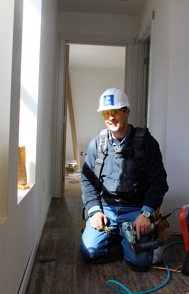 Habitat volunteer Mark Morris nails in trim in one of the townhouse hallways being completed in Oak Harbor. Morris is one of a small group of volunteers who regularly help. ”Hang doors, put in floors and just building in general, that’s what we do,” he says. Photos by Patricia Guthrie/Whidbey News-Times