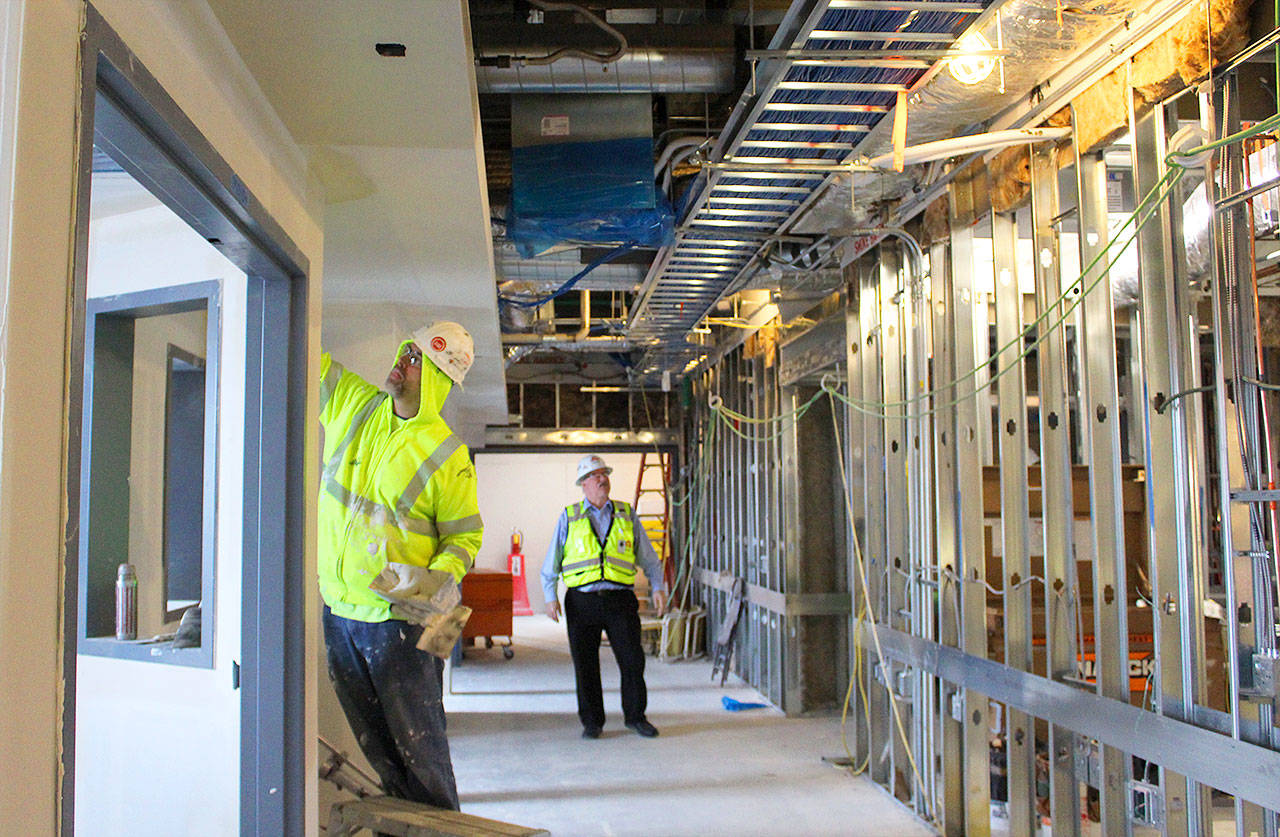 George Senerth (right) WhidbeyHealth executive director of facilities, checks on construction progress of the new addition. Its innovative heating and cooling system is predicted to reduce energy use by half. Photo by Patricia Guthrie/Whidbey News-Times