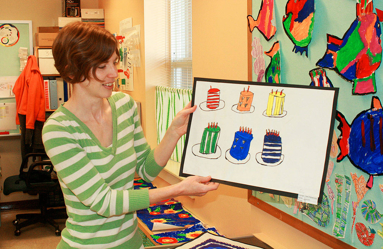 Christina Brady, the art specialist for Olympic View Elementary School, describes a student’s piece of art which is on display in the 16th Annual Elementary Art Walk in Pioneer Way businesses. Photo by Daniel Warn/Whidbey News-Times