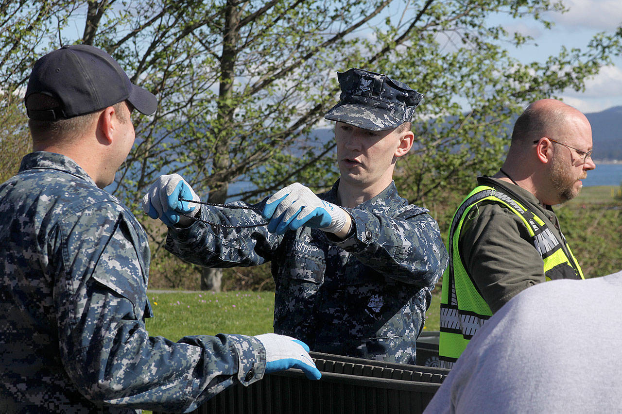 Aviation Support Equipment Technician 2nd Class Tyler Smith, right, holds up a necklace in front of Aviation Support Equipment Technician 2nd Class Ray Canafax during the annual Dumpster Dive competition as part of numerous Earth Day events at the base Friday, April 21, 2017. There also was a tree planting near the barracks at Ault Field. Photo by Ron Newberry/Whidbey News-Times