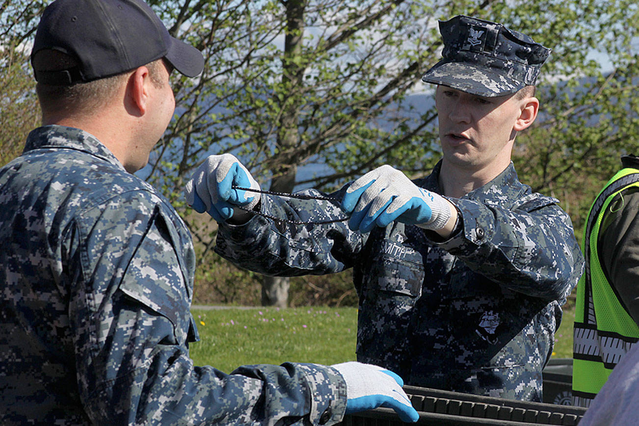 Aviation Support Equipment Technician 2nd Class Tyler Smith, right, holds up a necklace in front of Aviation Support Equipment Technician 2nd Class Ray Canafax during the annual Dumpster Dive competition as part of numerous Earth Day events at the base Friday, April 21, 2017. There also was a tree planting near the barracks at Ault Field. Photo by Ron Newberry/Whidbey News-Times