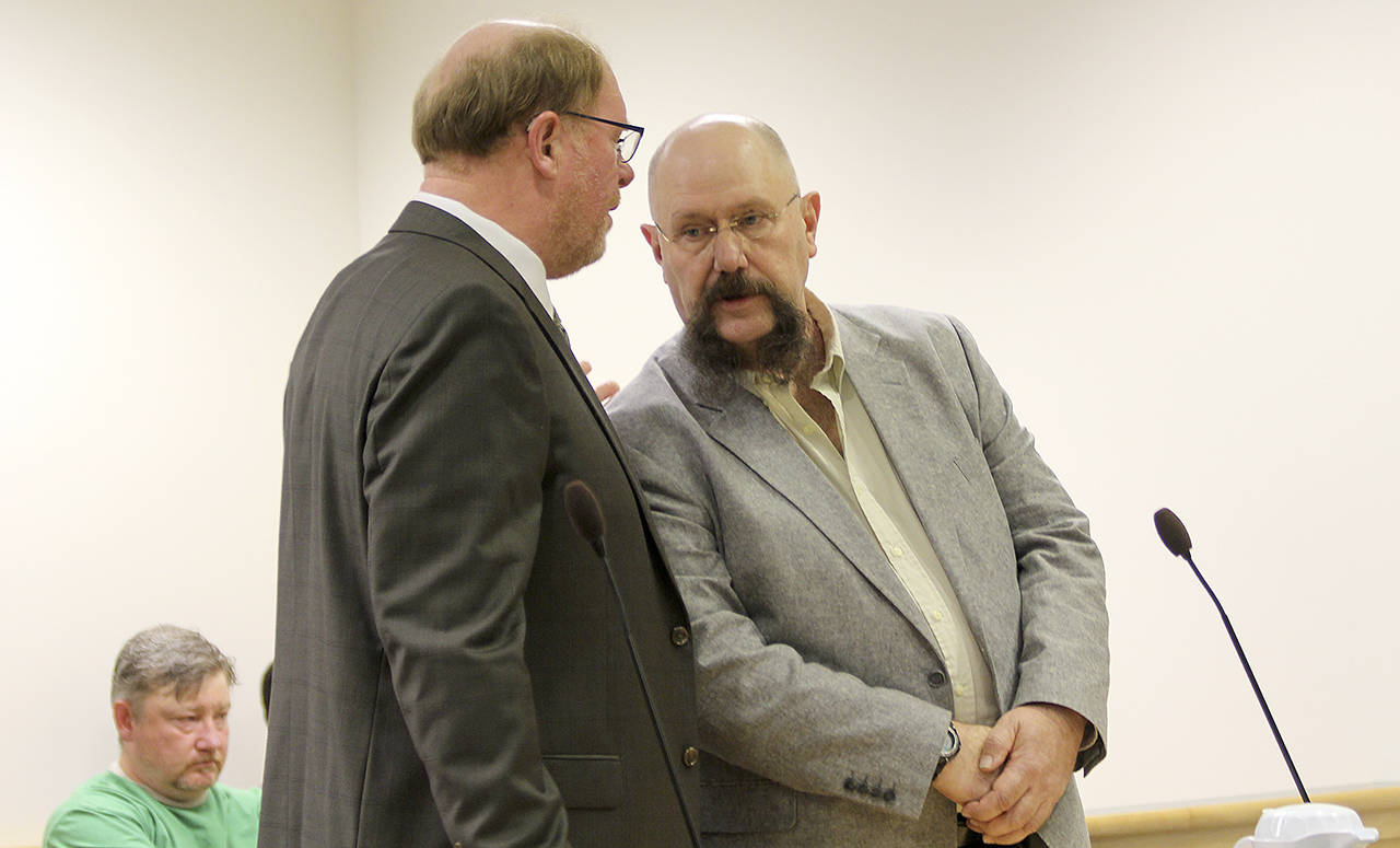 Former Island County corrections deputy Mark Moffitt speaks to his attorney, Craig Platt, in court Monday. Moffitt is facing a gross misdemeanor charge for allegedly falsifying a jail log after the death an inmate.
