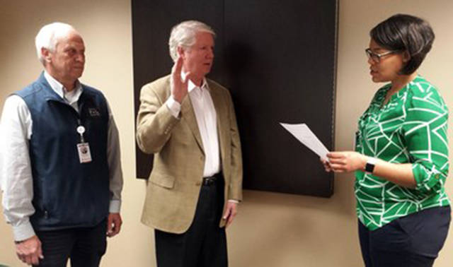 Kurt S. Blankenship is sworn in as District 2 Commissioner for Whidbey Island Public Health District by Lorrie Mendik, WhidbeyHealth employee. Board president Ron Wallin looks on.