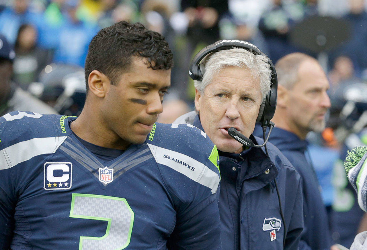 Seahawks quarterback Russell Wilson speaks with coach Pete Carroll about plans to train on Whidbey Island this summer.