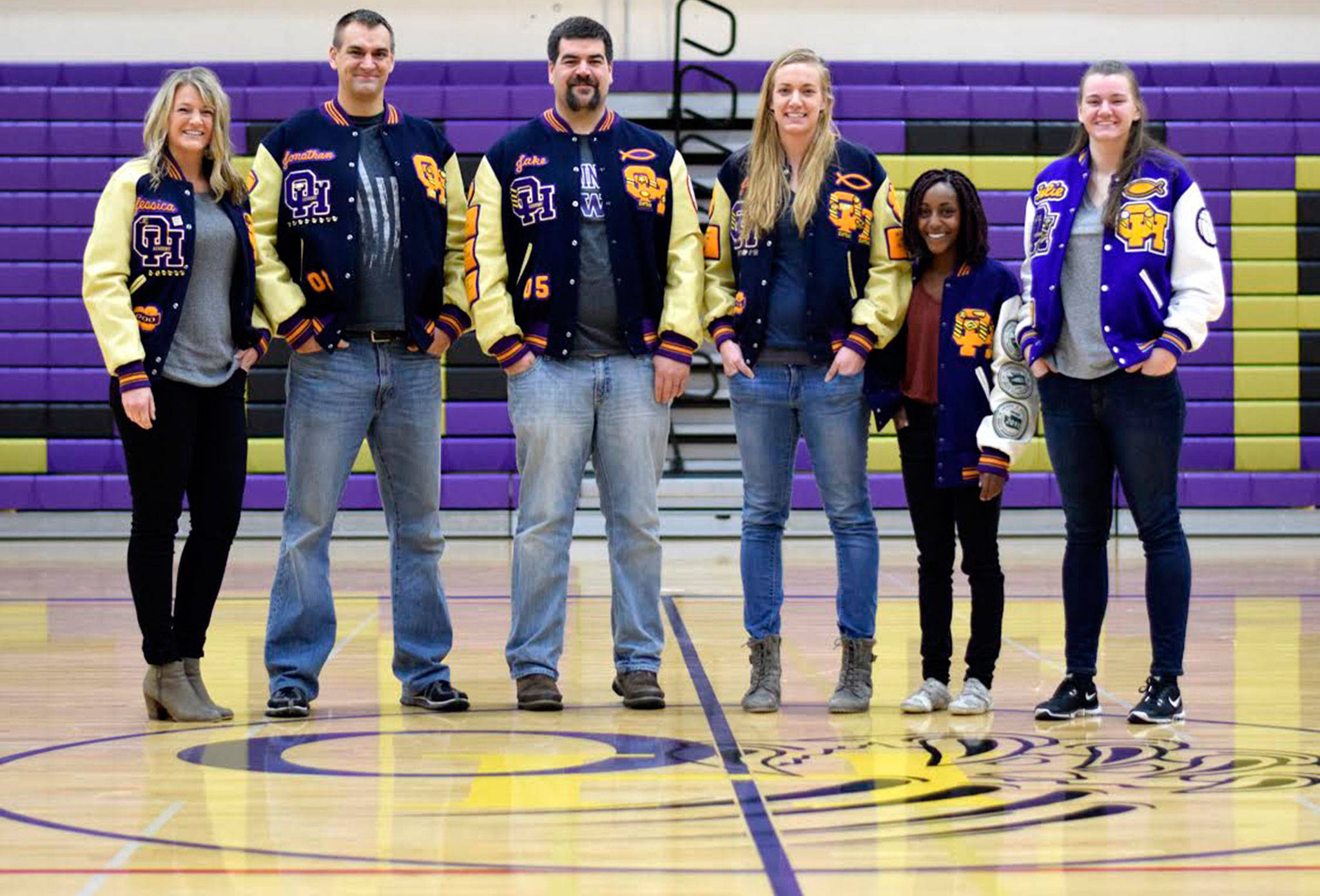 Six Jansen children show off their letter jackets at the Oak Harbor High School gymnasium. Jessica, left, Jon, Jake, Jennie, Jember and Julie combined to earn 48 varsitiy letters. (Photo by Emma Wezeman)