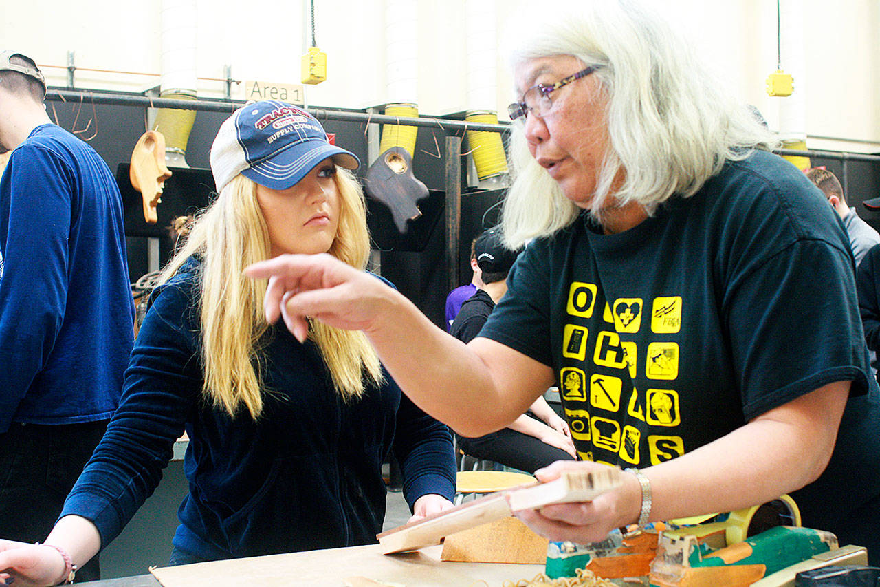 Guitar-building student Rylee Truex, left, works on her guitar under the tutalage of paraeducator Lynn Byers last month. Guitar building is part of Oak Harbor High School’s career and technical education program, supported by Levy dollars. Photo by Daniel Warn/Whidbey News-Times
