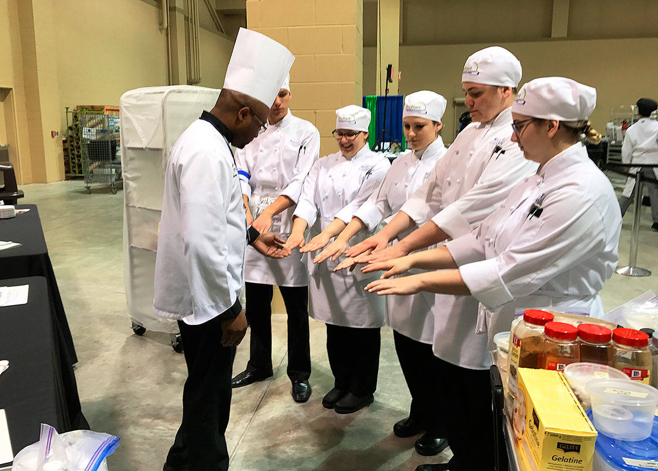 A judge checks the Oak Harbor culinary arts team for clean and sanitary hands at the ProStart National Invitational, which was held April 28-30 in Charleston, S.C. Oak Harbor placed 16th out of 48 teams. Photo courtesy Mary Arthur