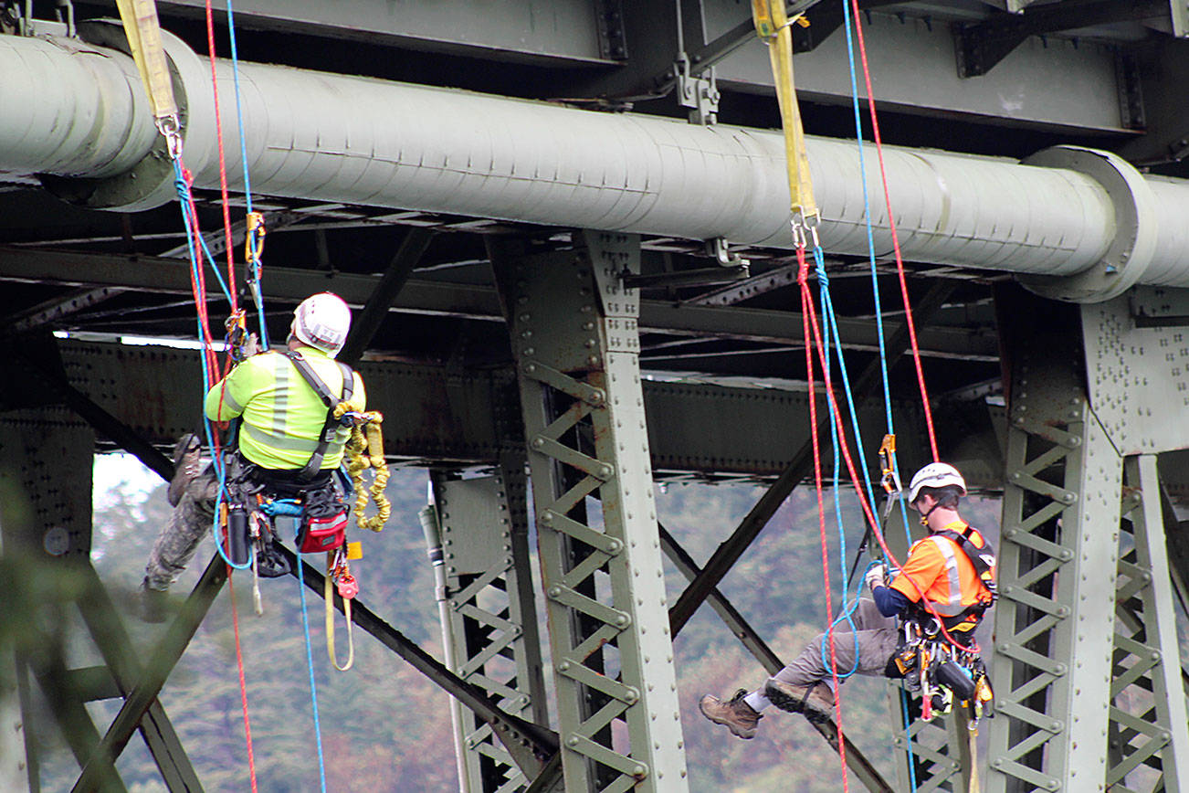 No fear: Climbers inspect the bridge up close