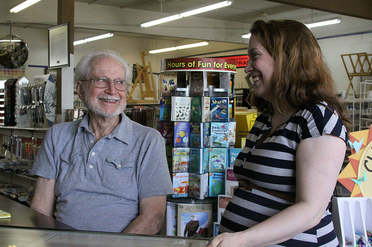 Eugene Phelps, owner of Gene’s Art & Frame, in his Oak Harbor store Thursday, May 4, 2017 along with store manager Linnane Armstrong. Phelps has been in business for 50 years. The store is celebrating its 50th anniversary in June. Photo by Ron Newberry/Whidbey News-Times.