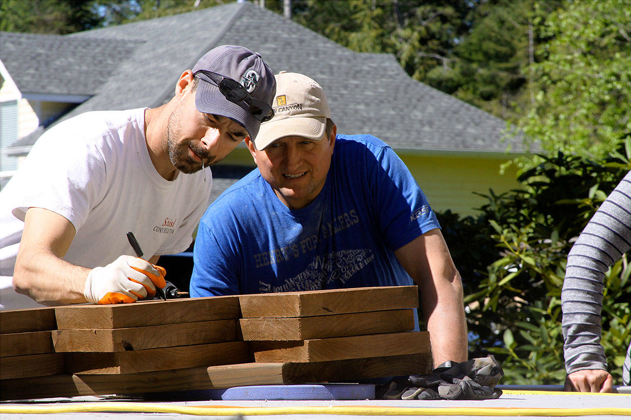 Jordan Schisel, left, determines the length of a cut during the Central Whidbey Hearts & Hammers&rsquo; annual work day Saturday, May 6, 2017 in Coupeville. The volunteer nonprofit group participated in 18 different projects to help their Central Whidbey neighbors Saturday. Photo by Ron Newberry/Whidbey News-Times
