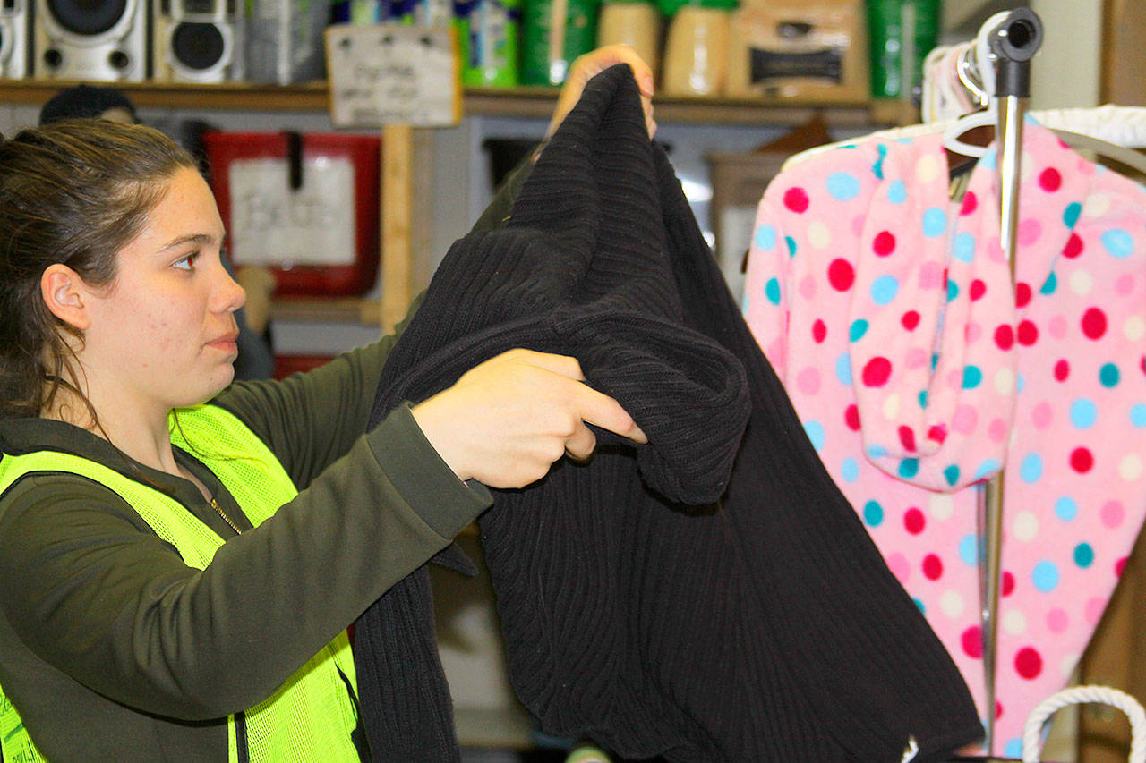 Volunteer Delaney Geist sorts through donated items at the Garage of Blessings in Oak Harbor, Thursday, May 18, 2017. The nonprofit thrift store will be moving to its sixth location in June. Photo by Ron Newberry/Whidbey News-Times