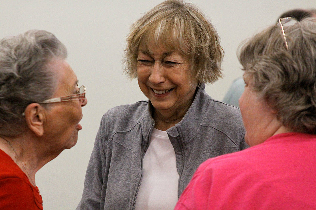 Anne Weaver, center, laughs while listening to Kathleen Anderson, left, at the Coupeville School Board meetingMonday. Weaver is retiring after 38 years in the Coupeville district. Photo by Ron Newberry/Whidbey News-Times
