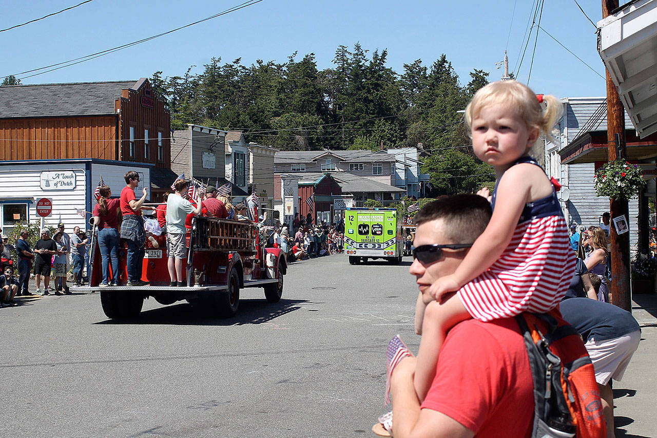 Oak Harbor resident Madelyn Belnap, 2, sits on Travis Belnap&rsquo;s shoulders as she watches Coupeville&rsquo;s Memorial Day Parade pass her by. Photo by Daniel Warn/Whidbey News-Times