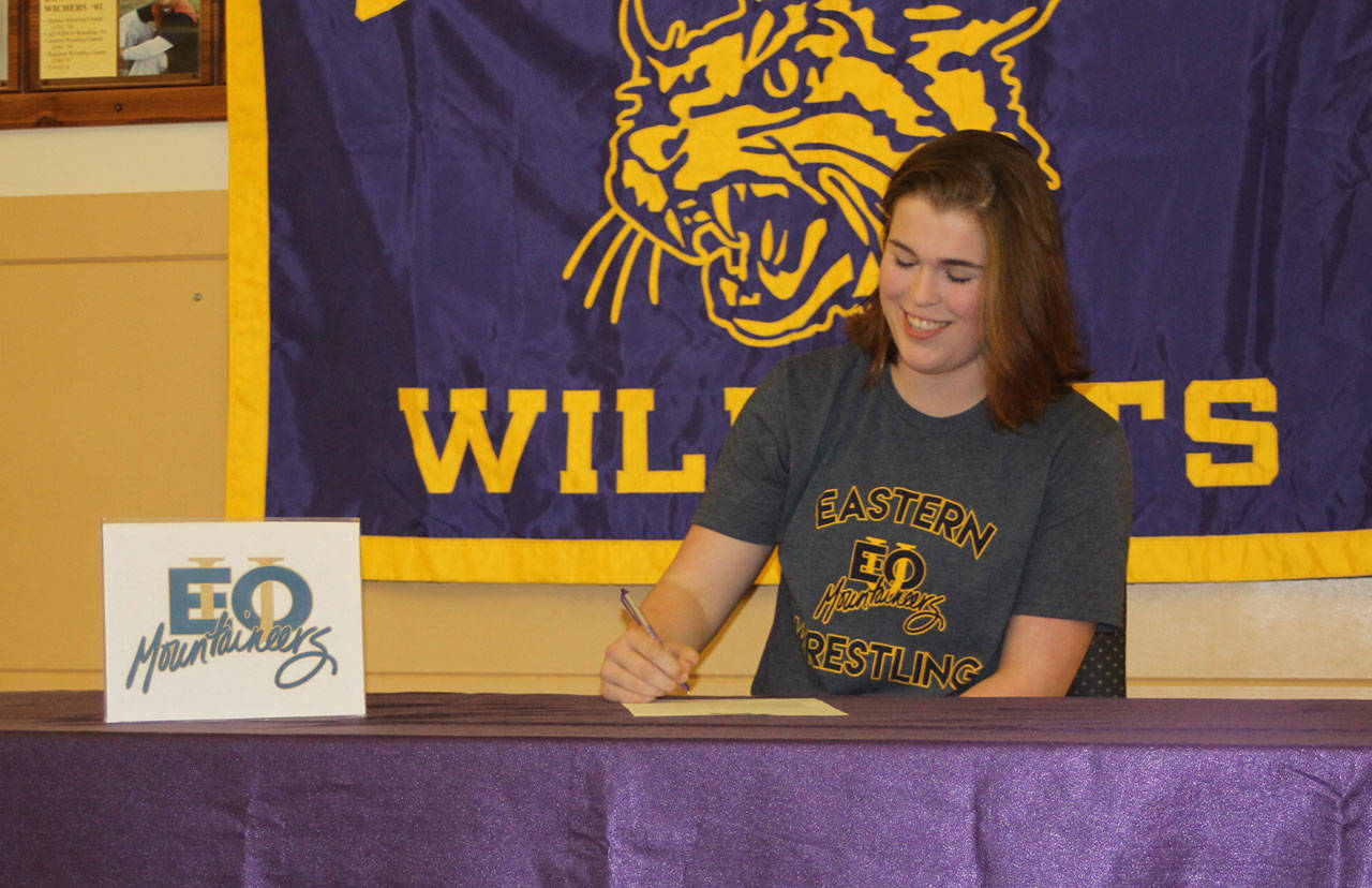 Meredith Bain signs a letter of intend Thursday to wrestle for Eastern Oregon University. (Photo by Jim Waller/Whidbey News-Times)