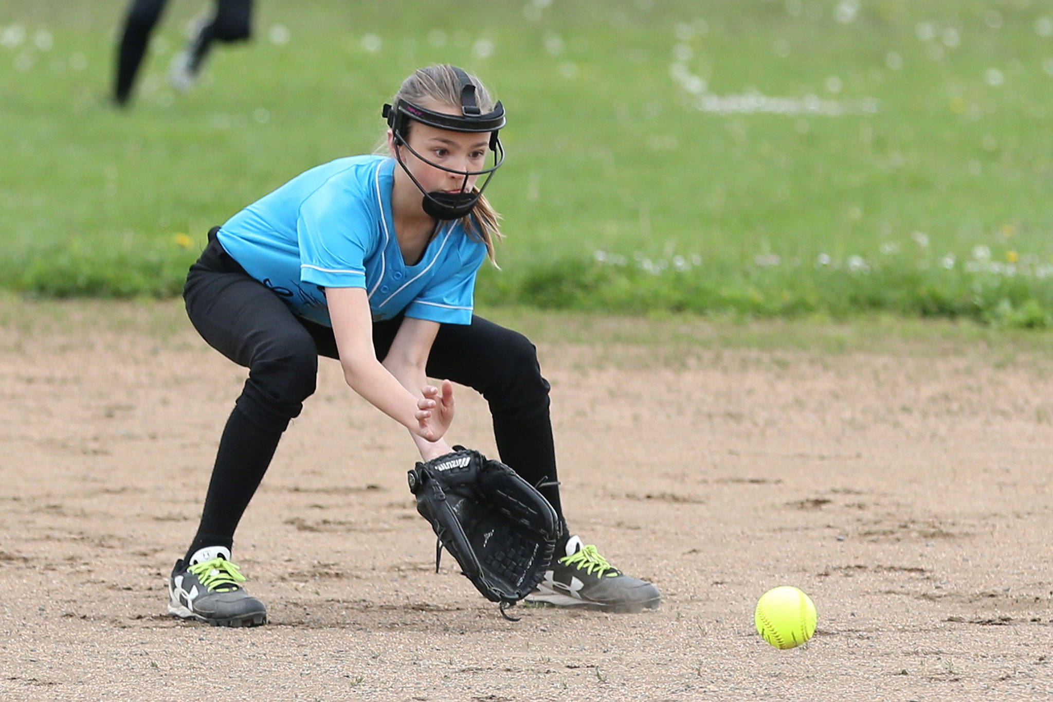 Central Whidbey’s Stella Johnson scoops up a grounder. (Photo by John Fisken)