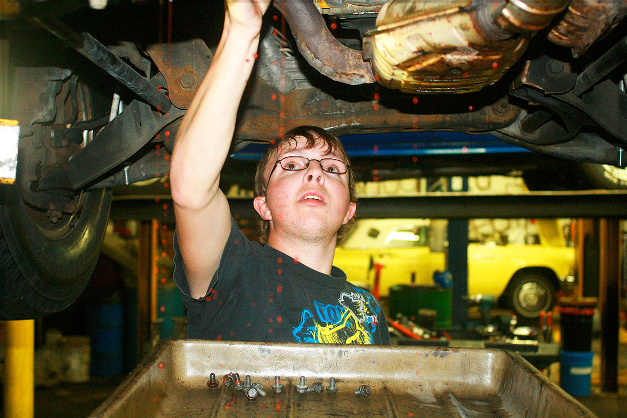 Doug Miller changes a transmission at Gateway Transmissions as part of his work in Oak Harbor Public Schools’ transition program, which helps students with developmental and learning disabilities successfully transition from high school into adult life. Photo by Daniel Warn/Whidbey News-Times