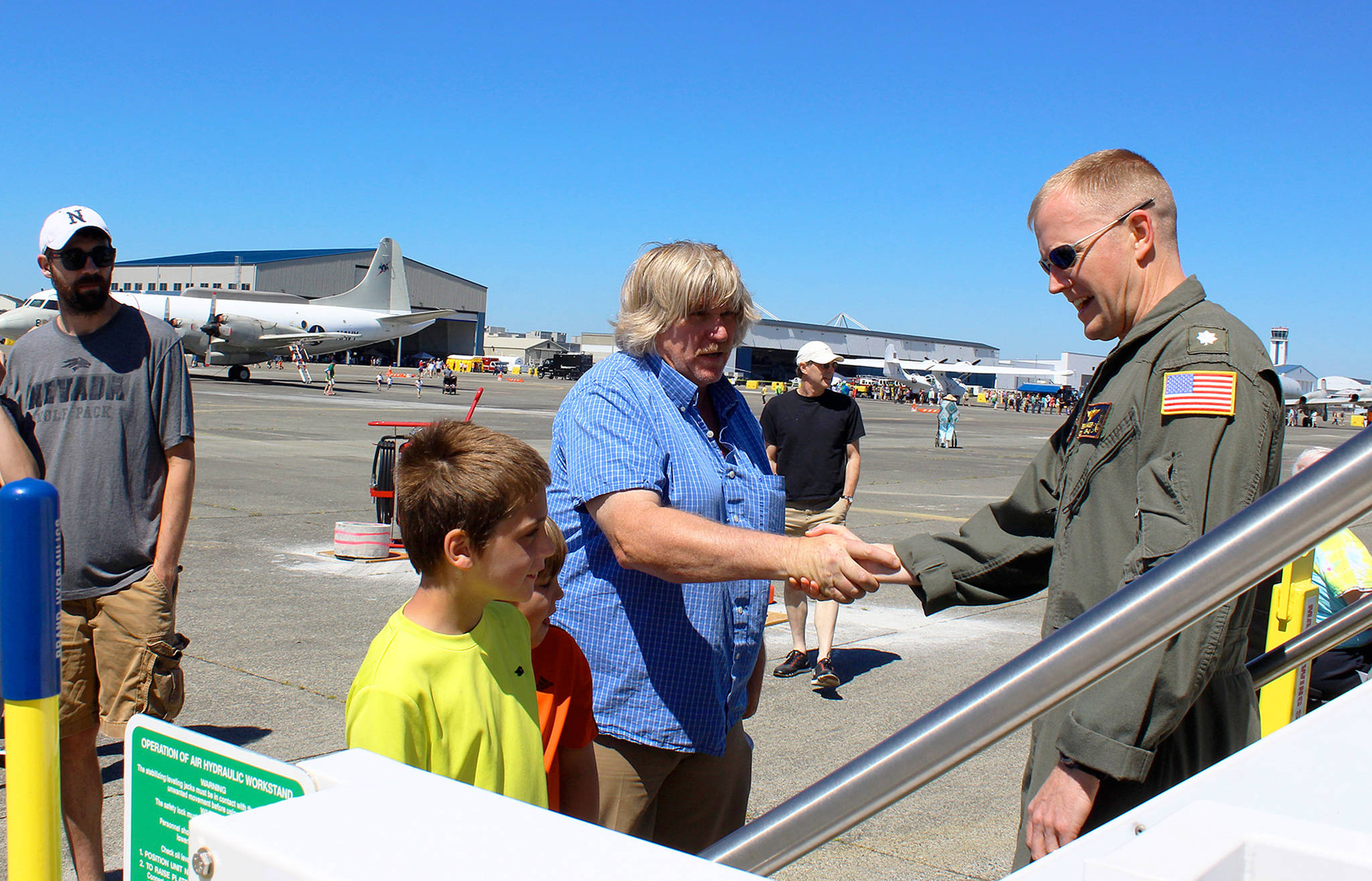 At Saturday’s NAS Whidbey Island Open House, a long line formed to get a peek inside the Navy’s brand new jet, Poseidon P-BA, just delivered from Boeing. Greeting visitors at the Poseidon entrance is Cmdr. Bryan Hager.                                Photo by Patricia Guthrie/Whidbey News-Times