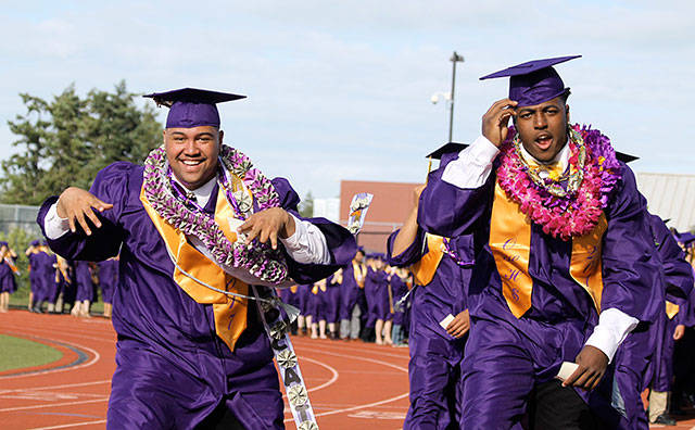 Oak Harbor High School seniors Princeton Lollar, left, and John Purcell dance along the processional toward their seats in the 2017 commencement ceremony Monday. Photo by Daniel Warn/Whidbey News-Times
