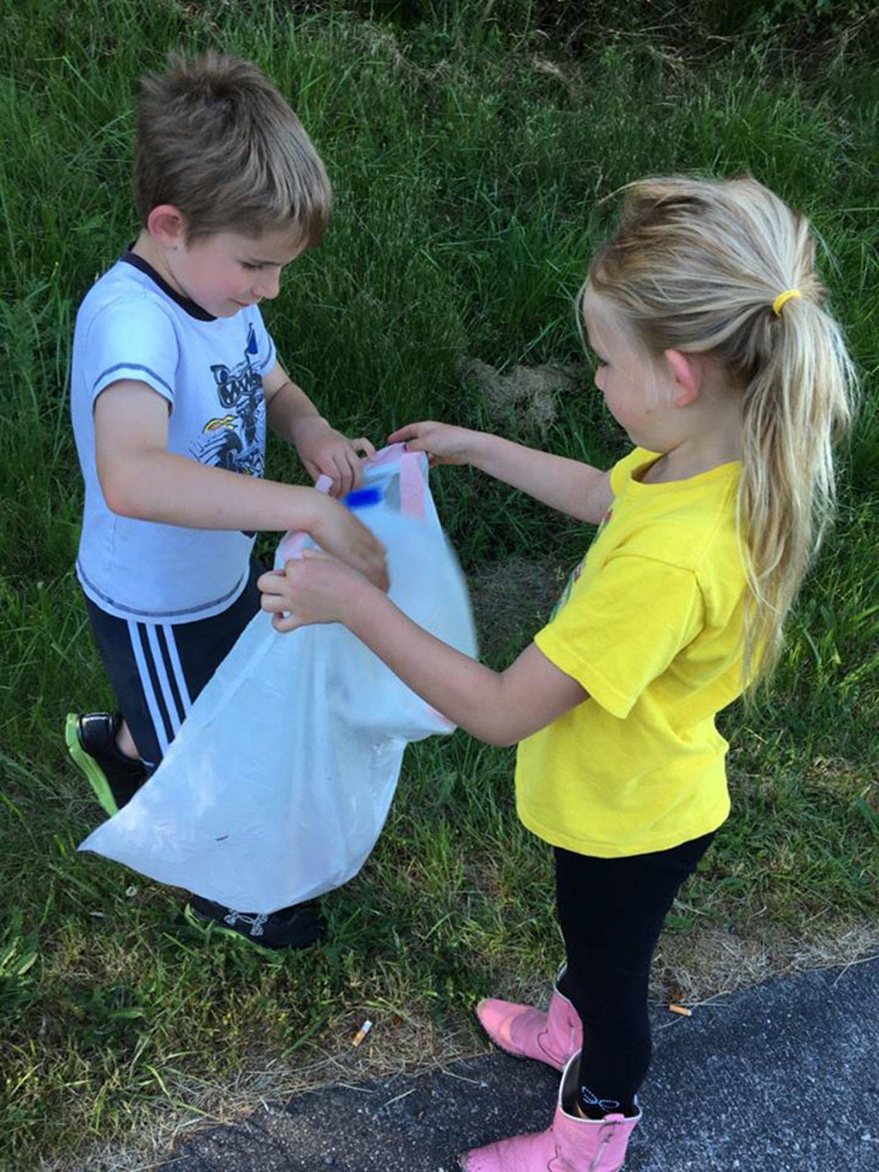 Proof that folks don’t need a sign to adopt and clean a roadway. While out for a stroll June 12 in Oak Harbor, Jack and Hyley Farrell decided they were tired of their town looking dirty and started picking up litter. Photo by Holly Peters Farrell