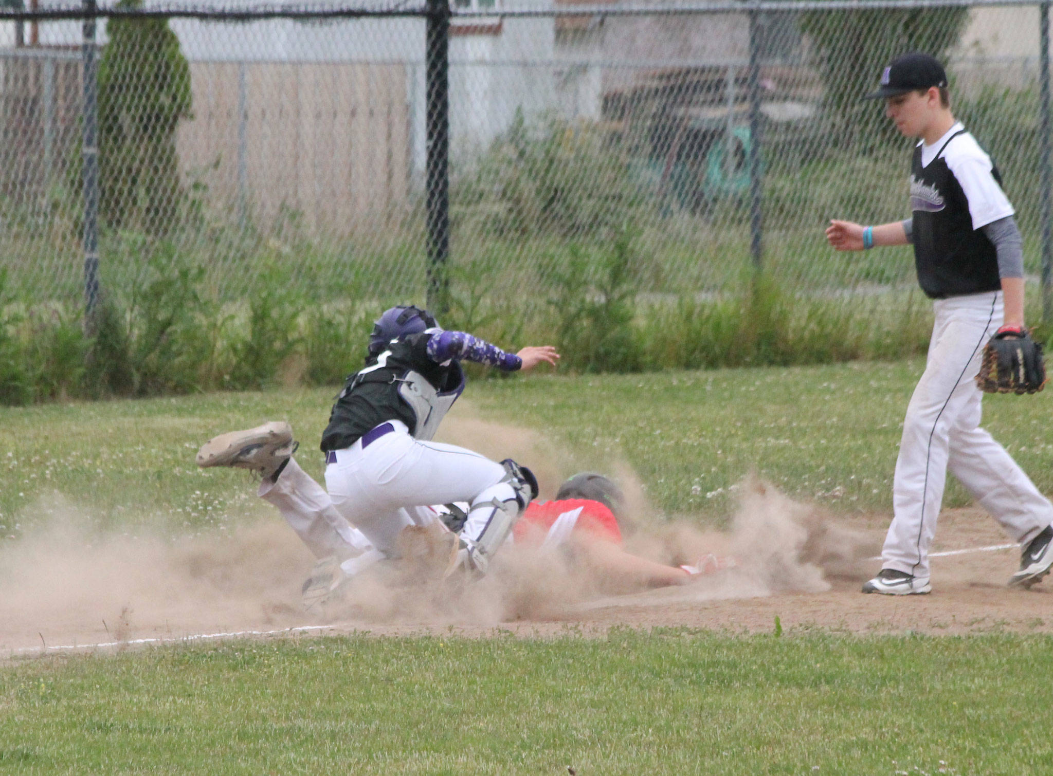 Gavin Knoblich dives safely into third base after escaping a rundown.(Photo by Jim Waller/Whidbey News-Times)