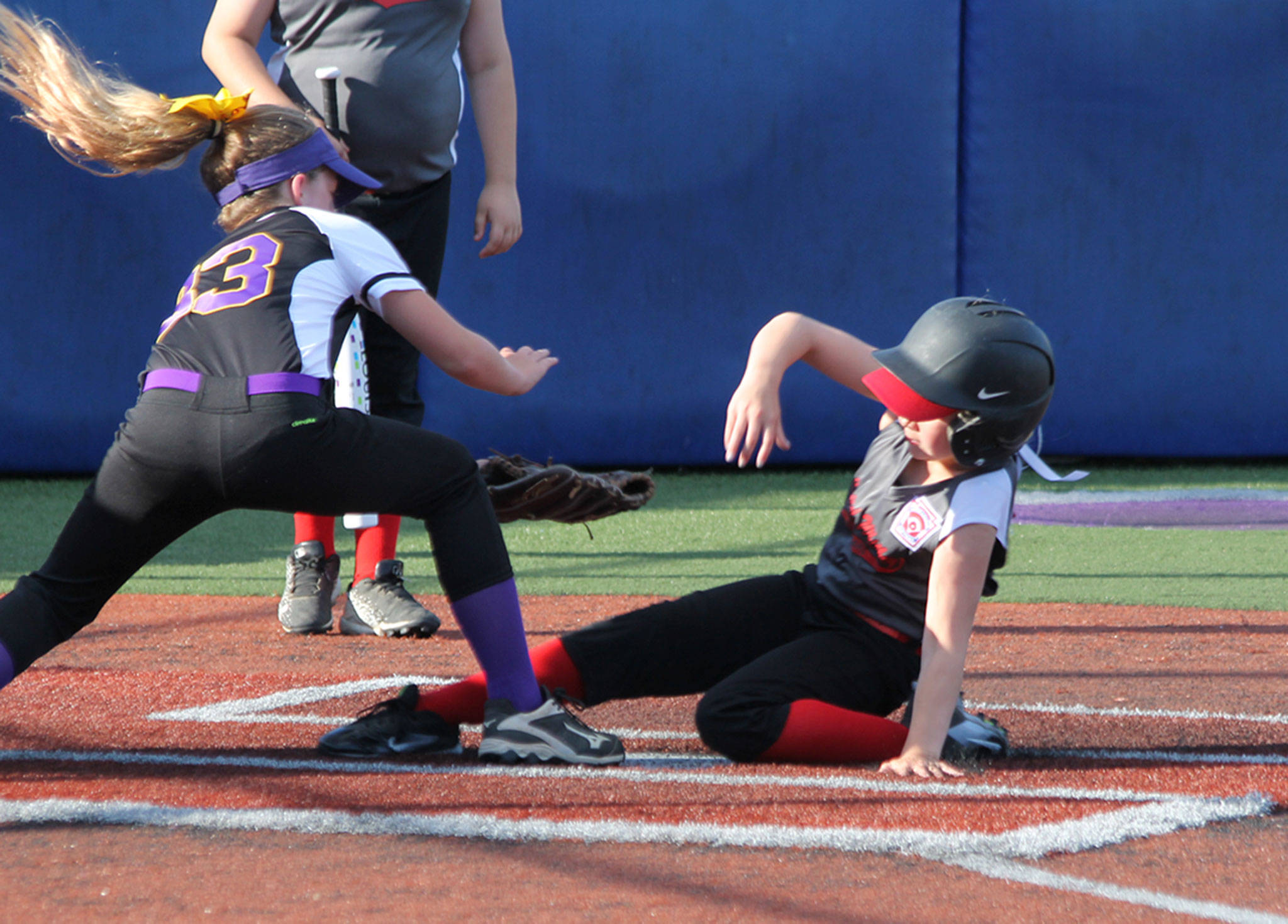 Central Whidbey’s Taylor Brotemarkle slides under the tag of Reese Wasinger. (Photo by Jim Waller/Whidbey News-Times)